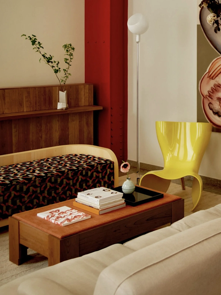 träbord, mönstrad soffa och en gul fåtölj