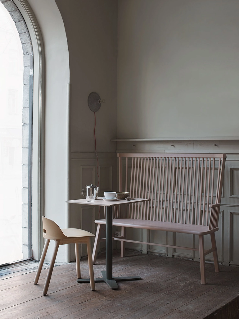 ljusrosa pinnsoffa med hög rygg vid ett litet cafébord